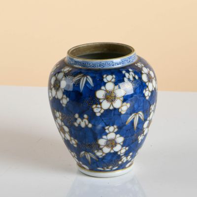 a blue vase with white flowers on it on a table