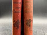 two old books sitting on top of a table next to each other