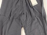 un pantalon gris posé sur une table blanche