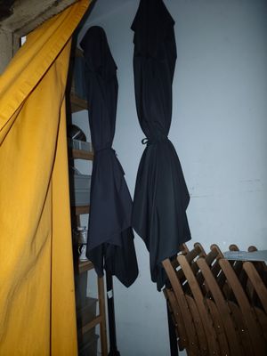deux parapluies accrochés au mur à côté d'une échelle