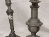 three silver metal candlesticks sitting next to each other on a white cloth