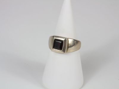 a close up of a ring with a black stone on it