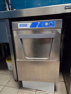 stainless steel dishwasher in a commercial kitchen with blue tiles