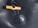 the handle of a black leather bag with a wooden handle