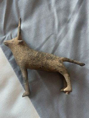 un petit chien en peluche allongé sur un lit
