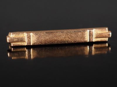 un gros plan d'un stylo doré posé sur une surface noire