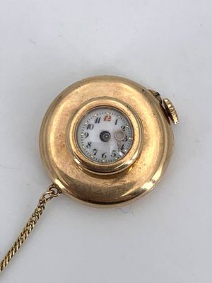 an image of a gold pocket watch with a chain on a white surface