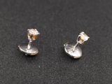 une paire de boucles d'oreilles en argent sur un fond noir