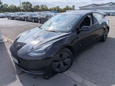 La Tesla Model 3 noire est garée sur un parking