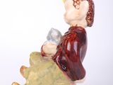 a figurine of a man sitting on a rock