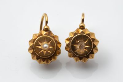 an image of a pair of gold earrings on a white surface