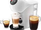 a close up of a cup of coffee next to a coffee maker