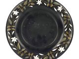 a close up of a black plate with white flowers on it