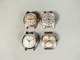 four different types of watches are displayed on a white surface