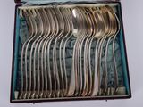 a lot of silver spoons in a box on the table