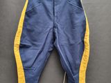 un pantalon bleu avec des bordures jaunes suspendu à une corde à linge