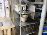 a kitchen with stainless steel shelvings and a sink