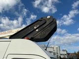 un camion blanc équipé d'une grue sur le toit