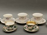 several cups and saucers are lined up on a table