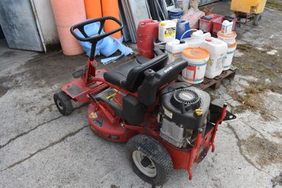 une tondeuse à gazon rouge garée devant un garage
