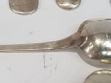 silver spoons and spoon rest on a white surface with other silver spoons and spoon rest on a white surface