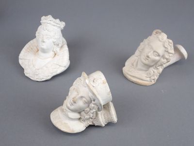 trois figurines en céramique blanche représentant une femme et un homme