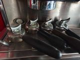 a close up of a coffee machine with a bunch of cups on it