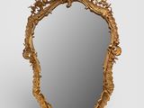 un miroir sculpté avec un cadre doré sur fond blanc