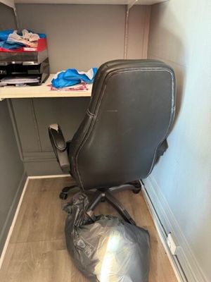 a desk with a chair and a bag on the floor