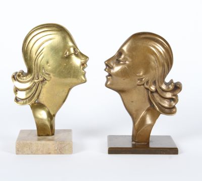 une paire de sculptures en laiton représentant une femme et un homme se faisant face