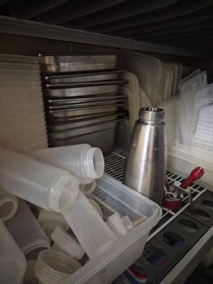 a drawer full of cups and other items in a kitchen