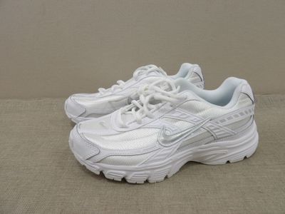 a close up of a pair of white sneakers on a beige surface