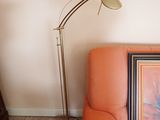 un canapé orange sur lequel est posé un tableau, à côté d'une lampe