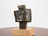 une sculpture représentant un homme tenant un morceau de bois posé sur une table