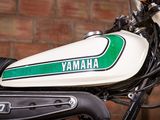 a close up of a motorcycle parked in front of a brick wall