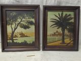 two framed paintings of a beach scene with palm trees and buildings