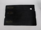 three black business cards sitting on top of a table next to a box