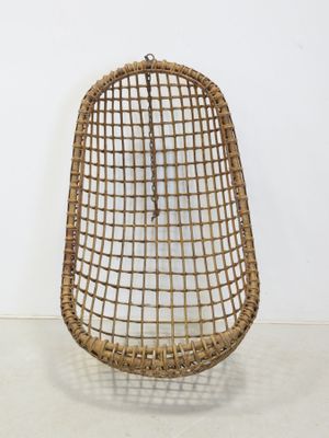 a wicker chair with a metal frame on a white floor