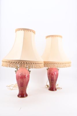 pair of red and gold lamps with fringe lampshads on white background