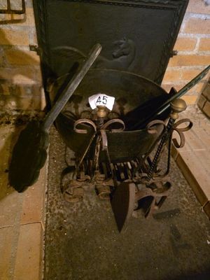 une vieille marmite en fer contenant un couteau et d'autres ustensiles