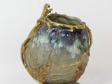 a green vase with a bird on top of it