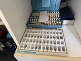 two trays filled with different types of screws on a table
