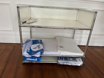 une étagère métallique sur laquelle sont posés des livres et des magazines