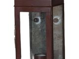 une lanterne marron contenant une tasse, sur fond blanc