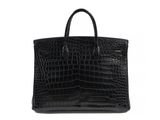 a black crocodile skin tote bag on a white background