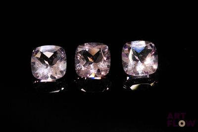 trois saphirs roses taille carrée sur fond noir