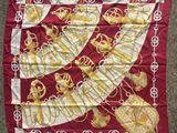 a close up of a red and gold scarf with a crown on it