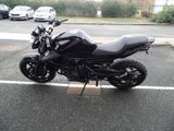 a black motorcycle parked in a parking lot next to some cars