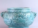 un grand vase bleu orné d'un motif représentant un dragon