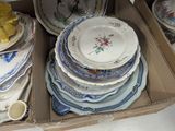a lot of plates in a box on the floor